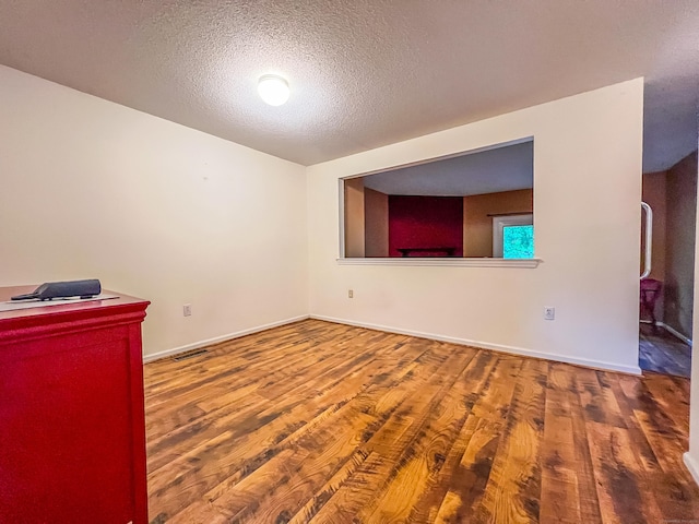 1516 E Main St Apt 18, Meriden, CT 06450 - unfurnished room with wood finished floors, a textured ceiling, and baseboards