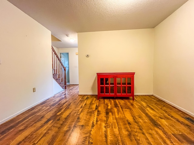 1516 E Main St Apt 18, Meriden, CT 06450 - unfurnished room with wood finished floors, stairs, a textured ceiling, baseboards, and a smoke detector