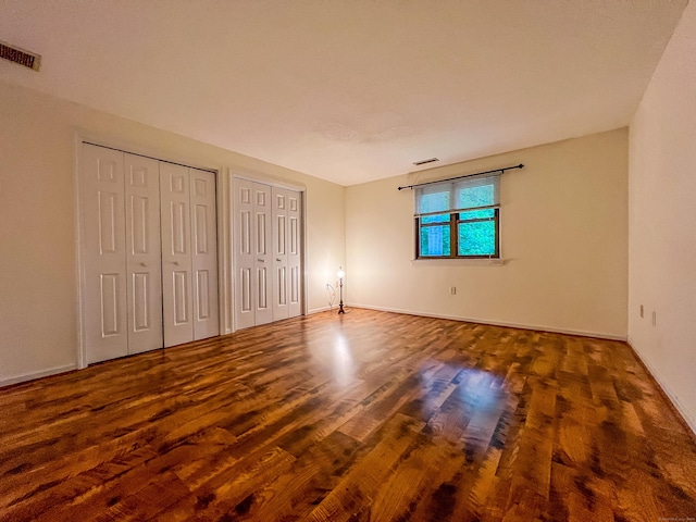 1516 E Main St Apt 18, Meriden, CT 06450 - unfurnished bedroom with multiple closets, wood finished floors, and baseboards