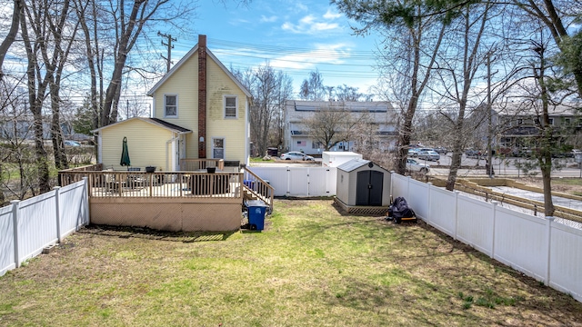 188 Meadow St, Branford, CT 06405 - rear view of property featuring a deck, a fenced backyard, a storage shed, and a lawn