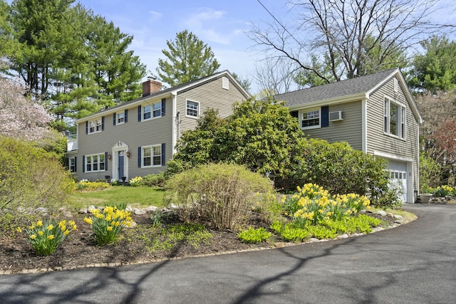 15 Maple Ln, Brookfield, CT 06804 - colonial home featuring a chimney, a garage, an AC wall unit, and driveway