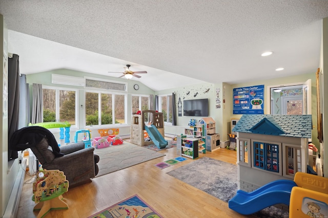 recreation room with ceiling fan, a textured ceiling, recessed lighting, wood finished floors, and vaulted ceiling