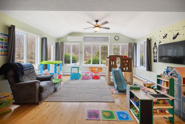 game room featuring a ceiling fan, an AC wall unit, wood finished floors, and lofted ceiling