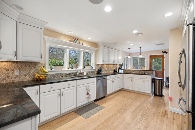 kitchen featuring stainless steel appliances, a healthy amount of sunlight, a sink, and a peninsula
