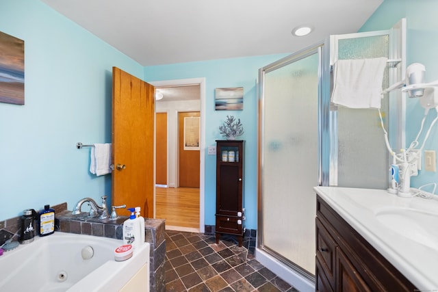 bathroom featuring vanity, a whirlpool tub, and a stall shower