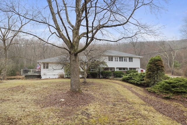 view of front facade featuring a deck and a wooded view