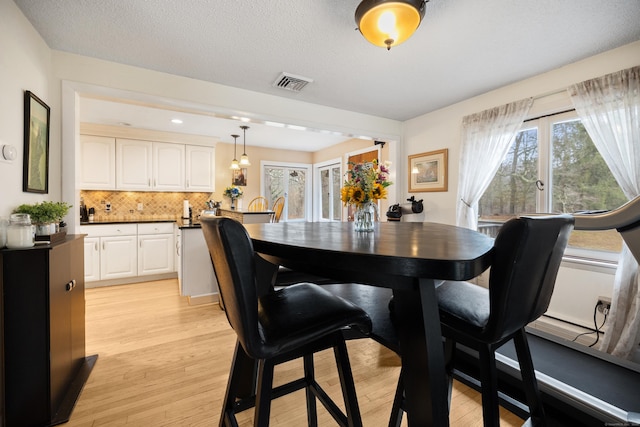 dining room featuring visible vents and light wood-type flooring