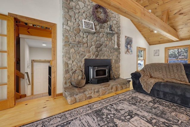 living area featuring stairway, a wood stove, wooden ceiling, beamed ceiling, and wood finished floors