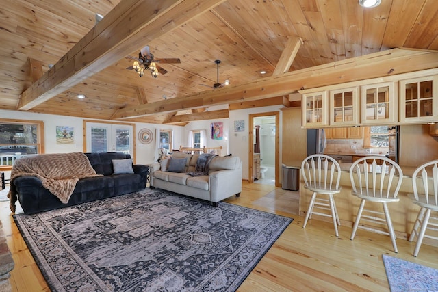 living area with lofted ceiling with beams, a wealth of natural light, and wood ceiling