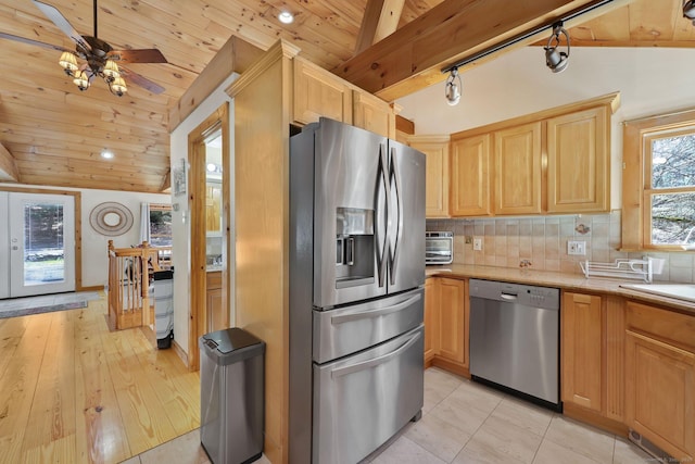kitchen with backsplash, appliances with stainless steel finishes, and lofted ceiling