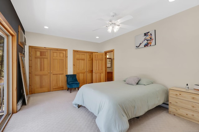 bedroom with two closets, light carpet, ceiling fan, and recessed lighting