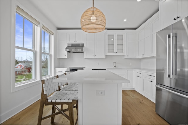 185 Main St Apt 301, East Lyme, CT 06357 - kitchen with high end refrigerator, under cabinet range hood, a sink, and a healthy amount of sunlight