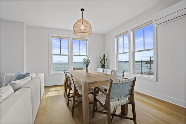 185 Main St Apt 301, East Lyme, CT 06357 - dining space featuring baseboards, a wall mounted AC, and light wood finished floors