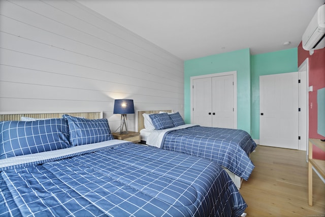 185 Main St Apt 301, East Lyme, CT 06357 - bedroom featuring a wall mounted AC, a closet, and wood finished floors
