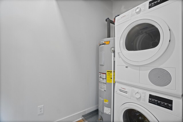 185 Main St Apt 301, East Lyme, CT 06357 - clothes washing area featuring laundry area, baseboards, water heater, and stacked washer / dryer