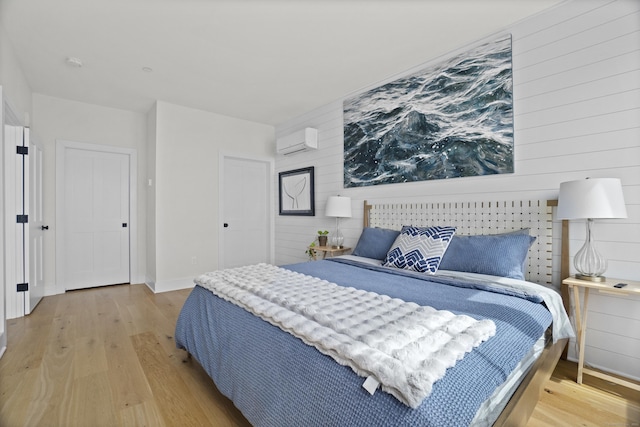 185 Main St Apt 301, East Lyme, CT 06357 - bedroom featuring wooden walls, baseboards, an AC wall unit, and wood finished floors
