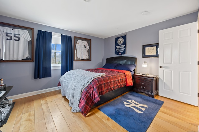 bedroom with baseboards and hardwood / wood-style flooring