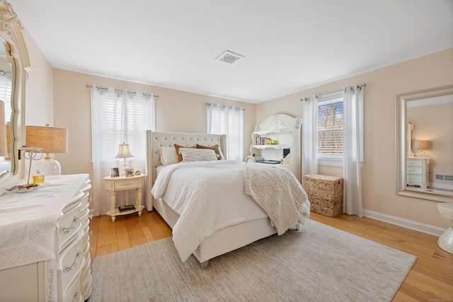 bedroom featuring baseboards, visible vents, and light wood-type flooring