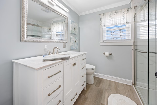 bathroom featuring crown molding, toilet, vanity, a shower stall, and wood finished floors