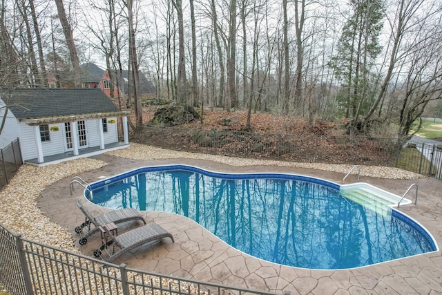 view of swimming pool with fence, an exterior structure, a patio, a fenced in pool, and an outdoor structure