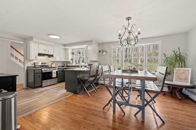 dining space featuring light wood-style flooring and an inviting chandelier