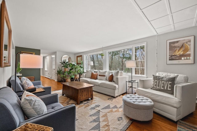 living room with baseboard heating and wood finished floors