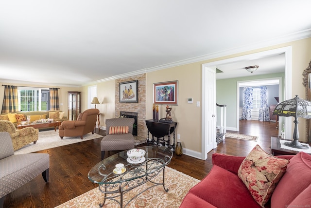 living area with ornamental molding, a wealth of natural light, wood finished floors, and a fireplace