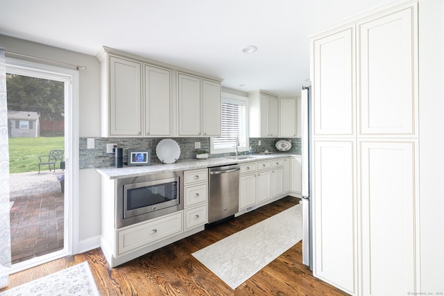 kitchen with decorative backsplash, a sink, appliances with stainless steel finishes, recessed lighting, and dark wood-type flooring