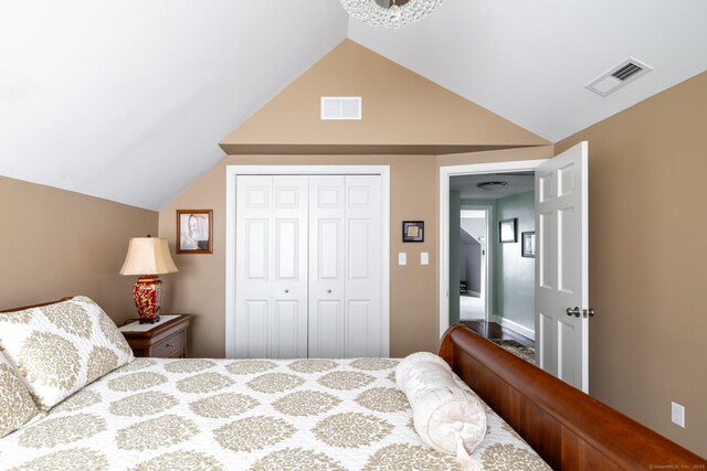 bedroom with a closet, visible vents, and vaulted ceiling