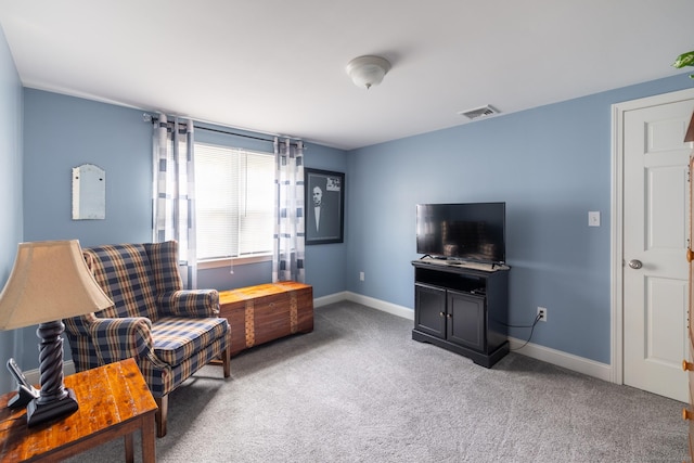 living area featuring baseboards, visible vents, and carpet flooring