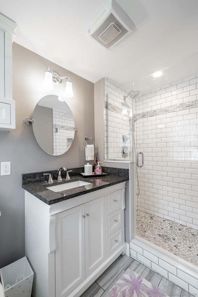 bathroom featuring visible vents, vanity, and a stall shower