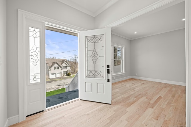 entrance foyer with crown molding, baseboards, and light wood-type flooring