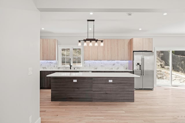 kitchen with light brown cabinets, modern cabinets, light countertops, and stainless steel fridge with ice dispenser