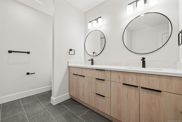 bathroom featuring baseboards, tile patterned floors, double vanity, and a sink
