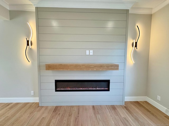 room details with ornamental molding, baseboards, wood finished floors, and a fireplace