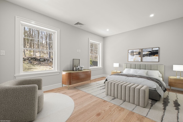 bedroom with wood finished floors, visible vents, recessed lighting, and baseboards