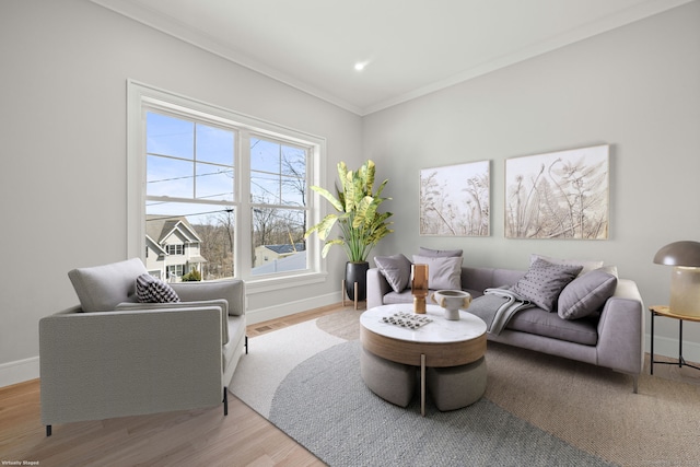 living room featuring baseboards, visible vents, ornamental molding, and wood finished floors