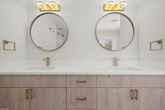 bathroom with visible vents, double vanity, and a sink