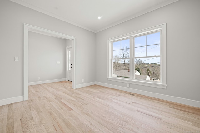 unfurnished room featuring crown molding, light wood finished floors, visible vents, and baseboards