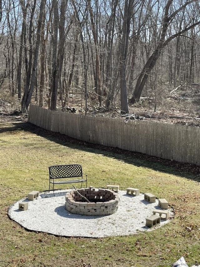 view of yard with a fire pit and fence
