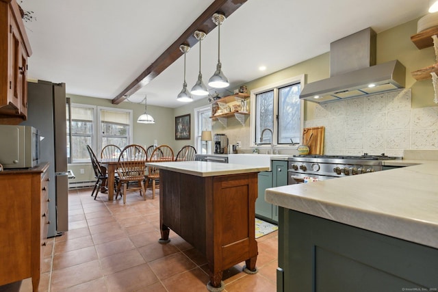kitchen featuring baseboard heating, decorative light fixtures, a sink, wall chimney exhaust hood, and tasteful backsplash