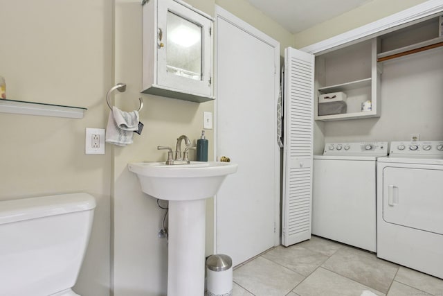 half bathroom with washing machine and clothes dryer, toilet, and tile patterned flooring