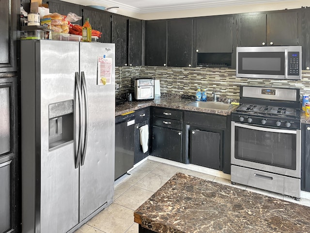 kitchen featuring appliances with stainless steel finishes, decorative backsplash, a sink, and dark countertops
