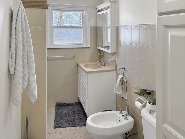 bathroom featuring tile patterned floors, vanity, a bidet, and tile walls