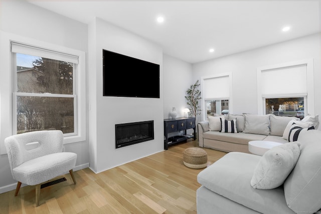 27 Hauser St, Milford, CT 06460 - living area featuring visible vents, recessed lighting, light wood-type flooring, and a glass covered fireplace