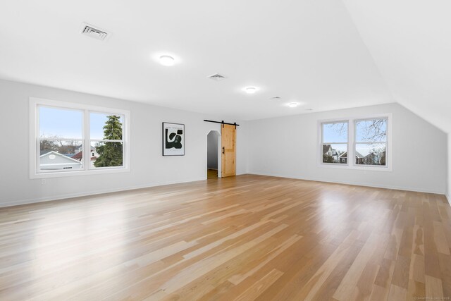 27 Hauser St, Milford, CT 06460 - unfurnished living room featuring visible vents, light wood-style flooring, a barn door, and baseboards