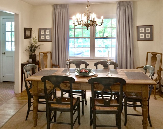 dining space with plenty of natural light, a chandelier, and light wood-type flooring