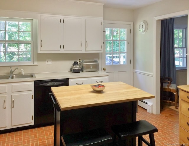 kitchen with a sink, brick patterned floors, butcher block counters, black dishwasher, and a baseboard heating unit