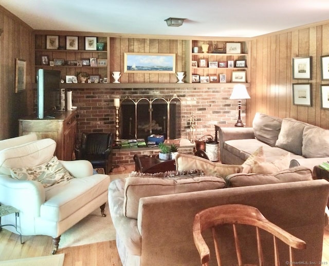 living room featuring wood walls, a fireplace, and wood finished floors