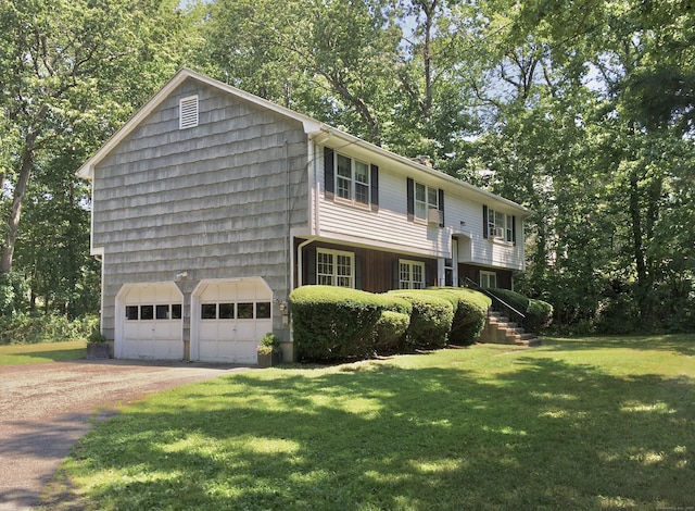split foyer home with a front lawn, driveway, and view of scattered trees
